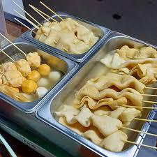 brochettes de gâteaux de poisson trempant dans une soupe